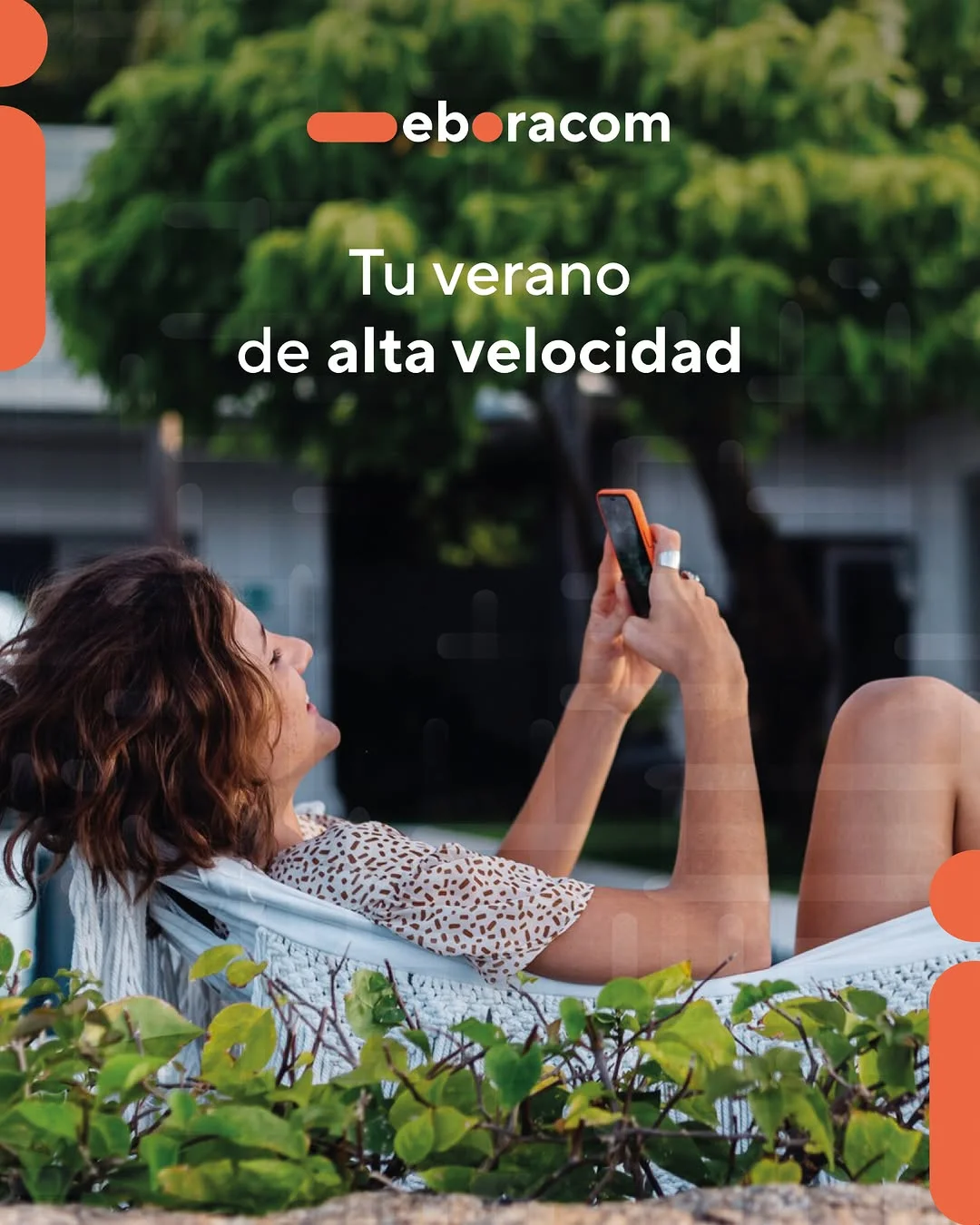 Mujer relajada en una hamaca disfrutando de la fibra en Talavera de Eboracom mientras consulta el móvil en verano